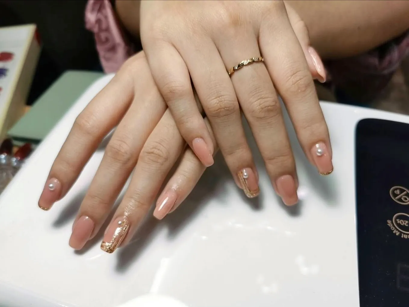 Nude gel manicure with pearl and gold foil accents